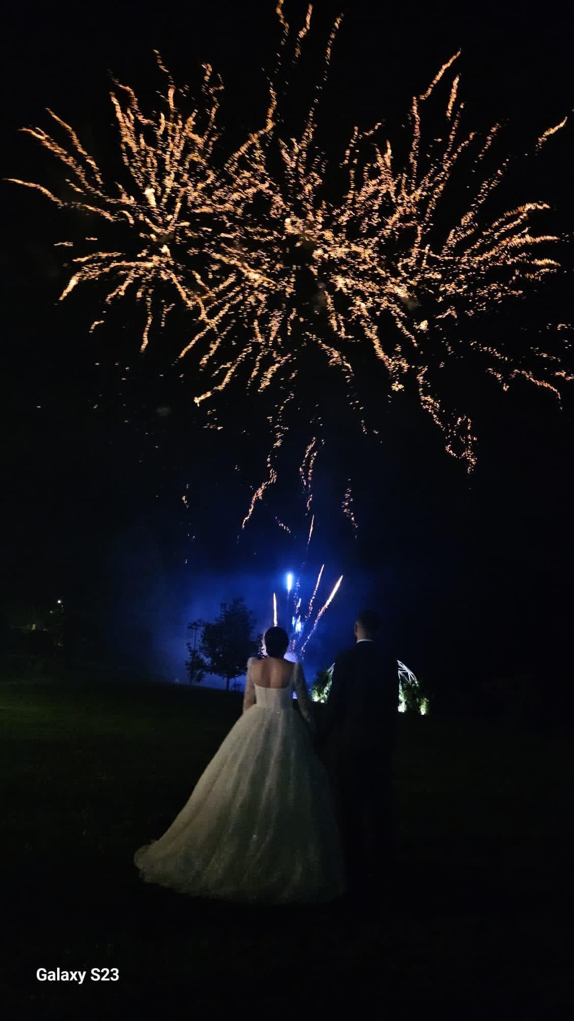 Couple de mariés regardant un feu d'artifice doré