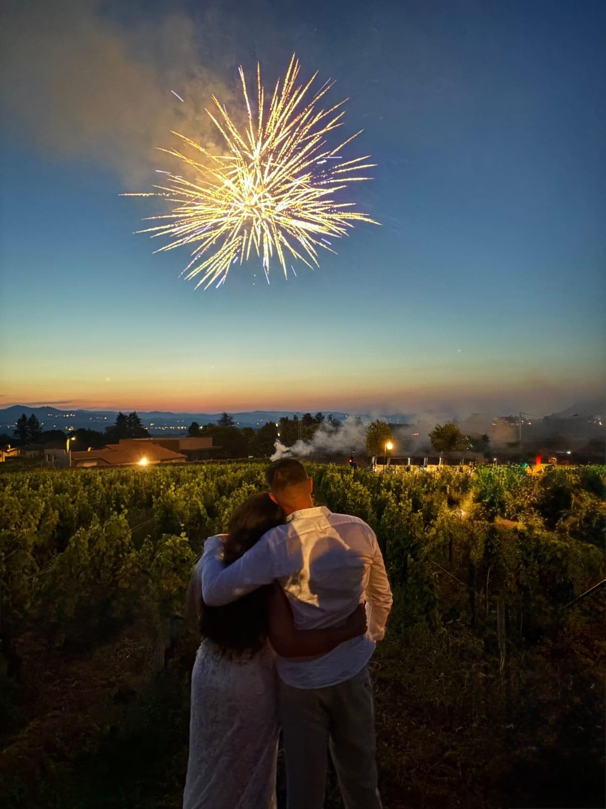 Couple enlacé devant un feu d'artifice au crépuscule dans les vignes — Éclats Étincelants